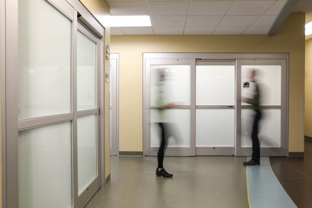 Modern clinic hallway with blurred motion of staff members walking, showcasing efficient and active healthcare environment