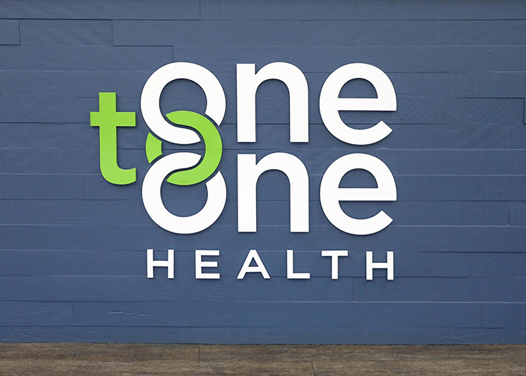 One to One Health logo on blue wall