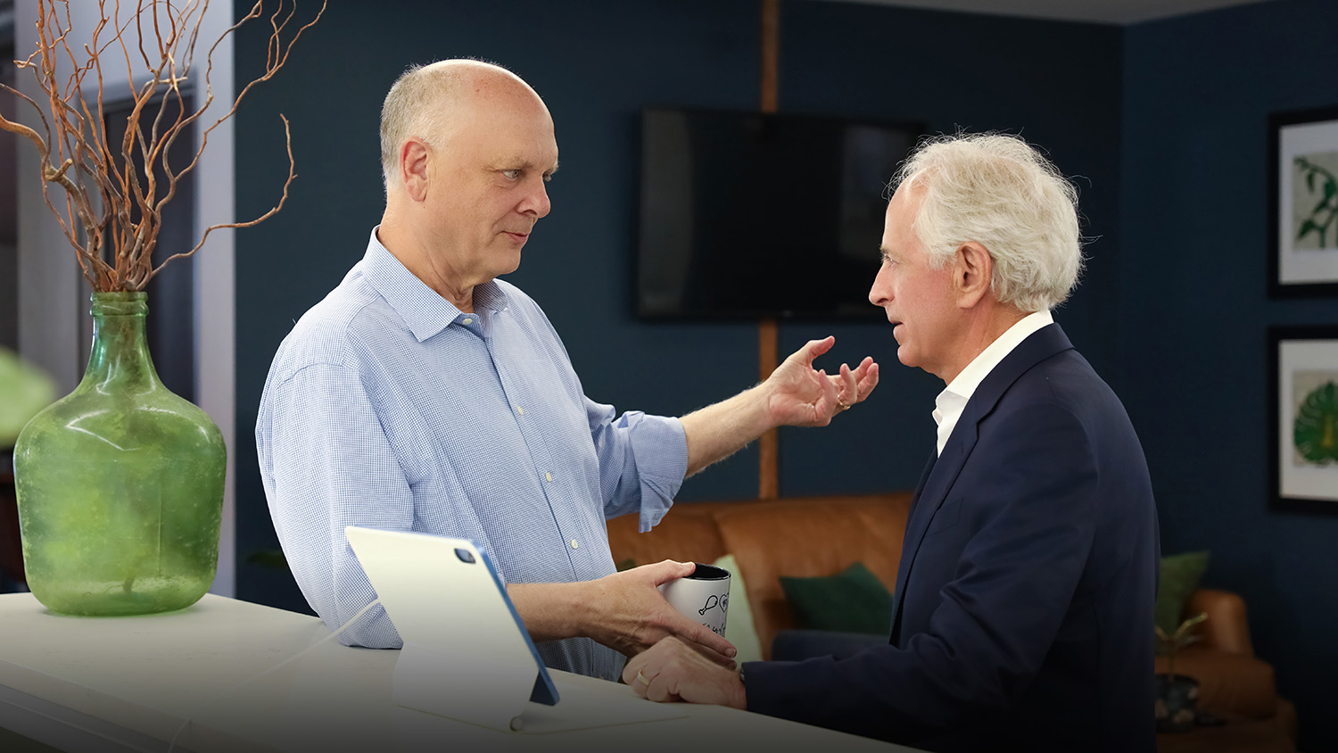 A photo of Founder Dr. Keith Helton and Chairman Bob Corker standing in conversation in the One to One Health headquarters